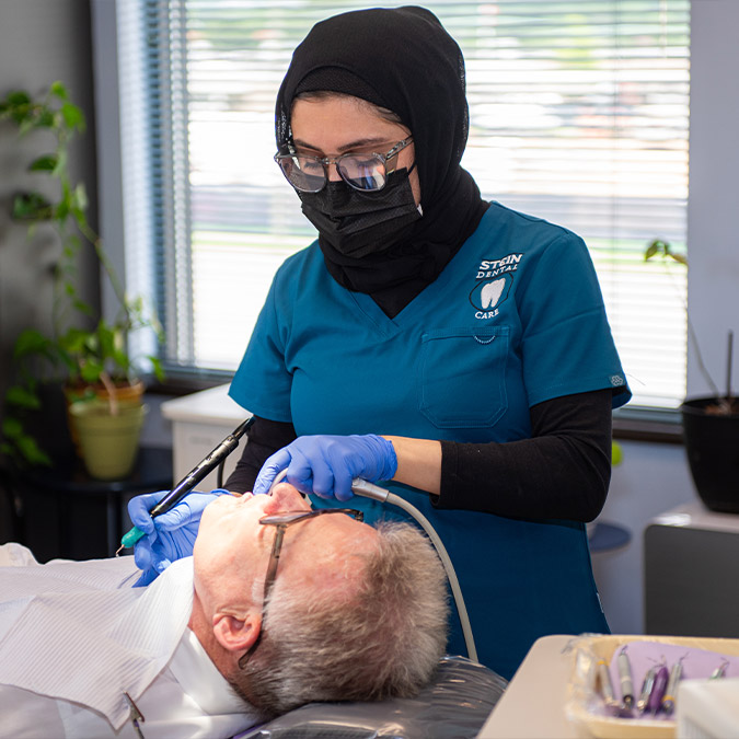 Dental hygienist performing a dental cleaning on a patient